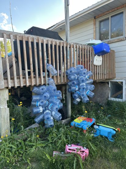 Des bouteilles en plastique vides sont suspenues à une terrasse de la Première Nation Neskantaga